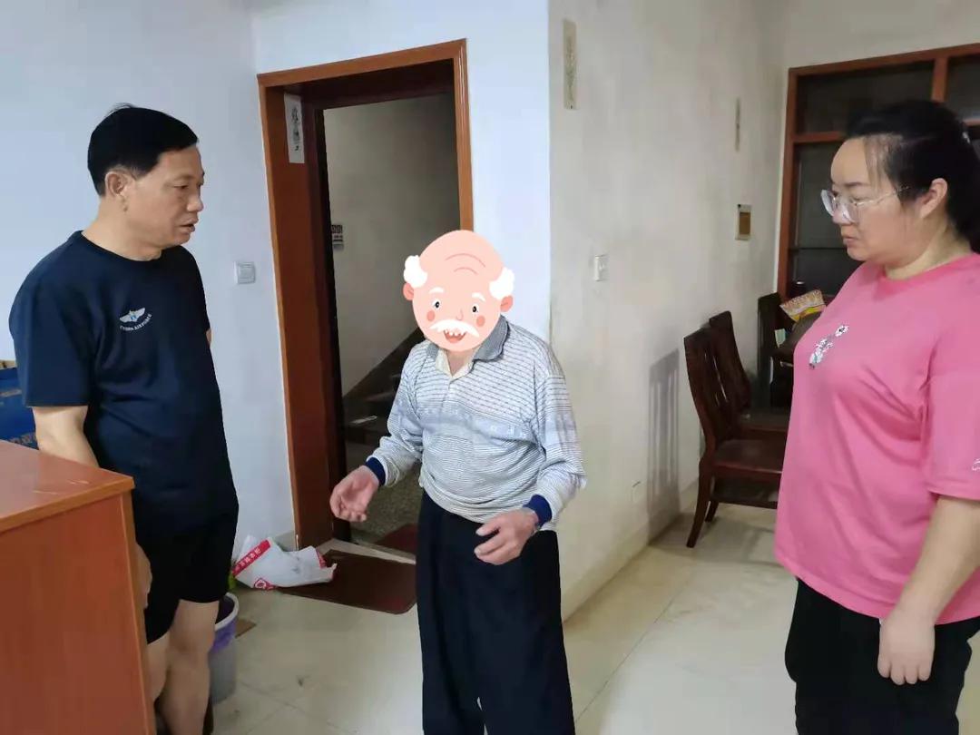 贺天红（左）与社区工作人员一起上门劝导老人