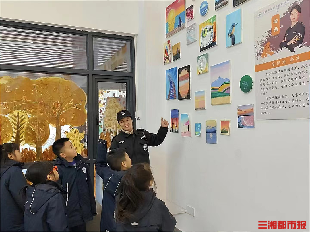 (鲁英正在给学生介绍画展展出的作品。高煜棋摄 )