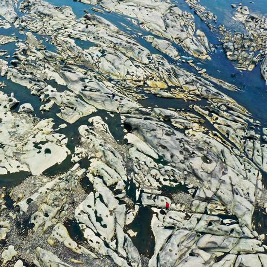 (资水流经桃江县泉峰滩时,其上蚀沟纵横、壶穴密布,蔚为壮不雅观。摄影/卢七星)