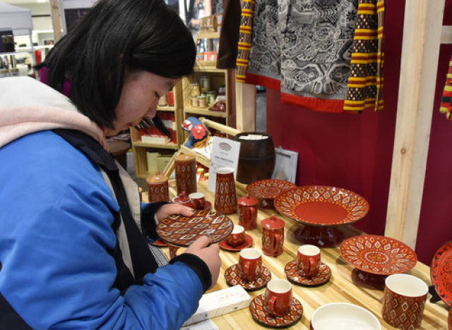 一名顾客在长沙一家商场挑选来自瑶乡的文创品(2月1日摄)。 新华社记者 白田田 摄