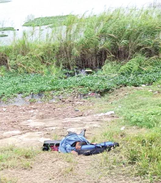 △ 9 月 20 日，岳阳北门渡口洞庭湖大桥旁，救人后累瘫在地的朱正祥。图 / 受访者提供