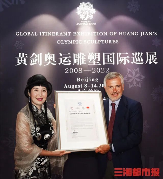 ▲国际奥委会副主席、北京2022年冬奥会协调委员会主席萨马兰奇（右）授予我校80级校友、中国雕塑艺术家黄剑（左）“奥运艺术使者"荣誉称号