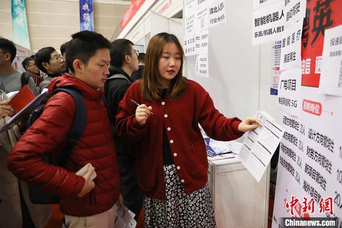 资料图为2019年10月30日,参加校园招聘的大学生与招聘单位交流。中新社记者 蒋启明 摄