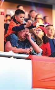  11月29日，一名邵阳队球迷带孩子来支持主队。