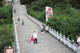 9月30日，张家界天门山景区，游客站在天门洞下方的台阶上拍照留念。