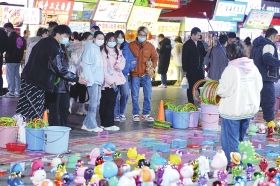 12月9日晚,长沙扬帆夜市,游人在地摊前驻足。图/记者杨旭