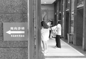 湘域国际中心,东门旁的告示提示市民在早高峰可以走南向步梯。图/记者张云峰
