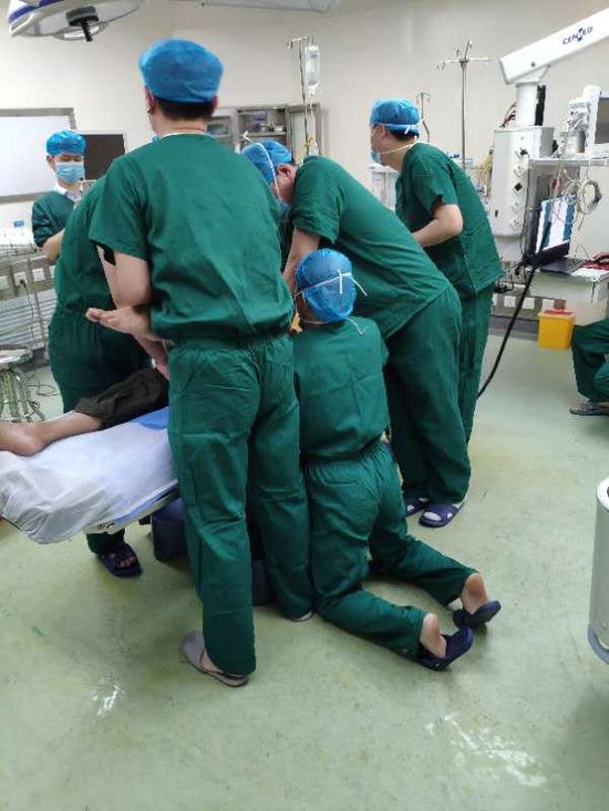 近日，郴州市第三人民医院，医生王文龙跪在地上做手术。图/受访者提供