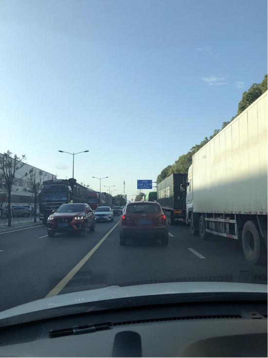 邮政物流周边道路两侧货运车辆占道停车。