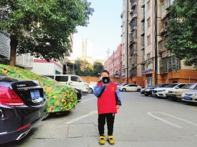 近日,长沙市天心区金盆岭街道天剑社区,喻天羿拿着喇叭宣传防疫知识。图/受访者提供