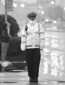 2月17日,长沙持续低温雨水天气,不管是骑自行车、电动车的市民,还是执勤的 交警,都把自己裹得严严实实。组图/潇湘晨报记者 辜鹏博