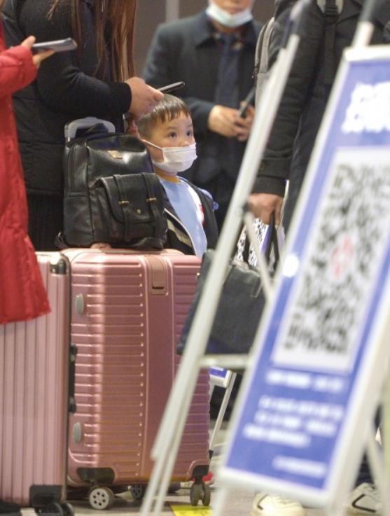  12 月 9 日，长沙火车南站，小朋友正在等待家长扫健康码，然后一起出站。图 / 记者吴琳红
