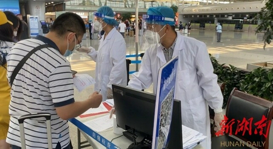 （8月3日，长沙机场T2航站楼，工作人员正在对旅客进行相关信息登记。和婷婷摄）