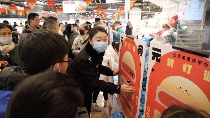 元宵节前夕,长沙市反诈中心民警在雨花区喜盈门范城的盒马鲜生门店外开展“全民反诈闹元宵”活动。