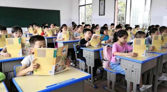 ▲雁西小学的学生们高兴地打开了新课本