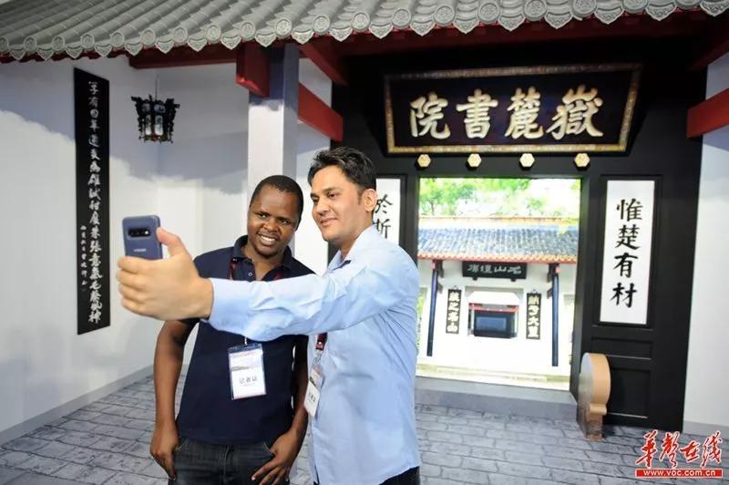 千年学府岳麓书院“来到”展览现场,两位外宾在此拍照打卡。