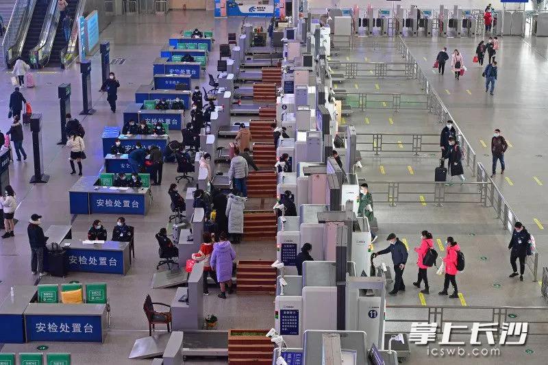 春运首日,戴着口罩的旅客有序通过长沙火车南站安检口
