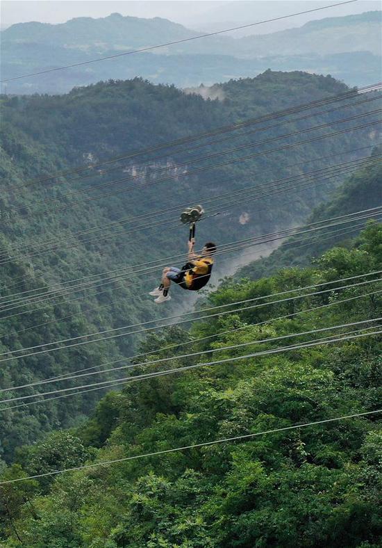 8月9日，游人在湖南张家界大峡谷景区体验高空滑索（无人机照片）。吴勇兵 摄