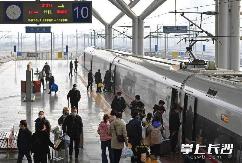 1月28日,长沙火车南站,戴着口罩的旅客有序排队上车