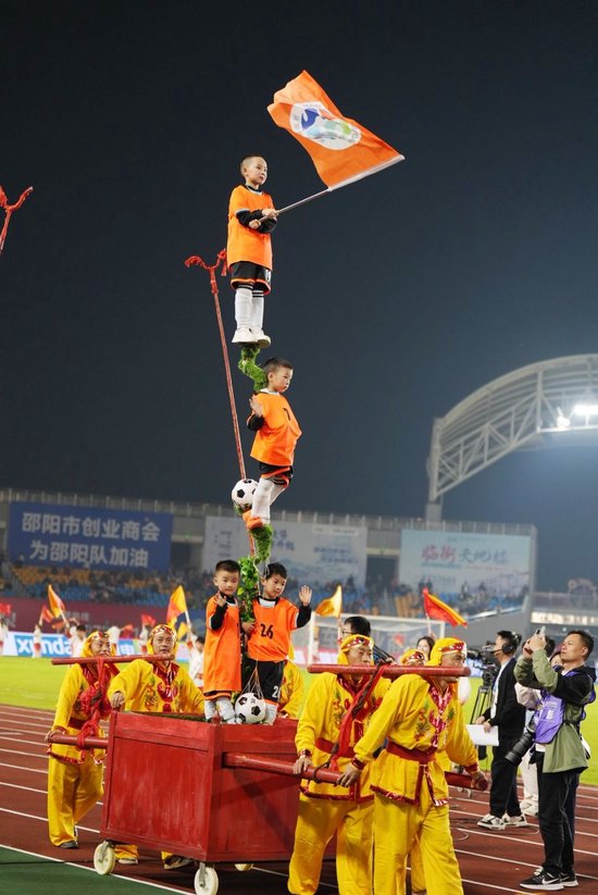 （非遗项目“踩高跷”“扎故事”惊艳湘超绿茵场 申兴刚摄）