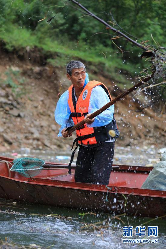 9月6日，在湖南省张家界市永定区茅岩河上，当地村民在清理漂浮物。新华社发（吴勇兵 摄）