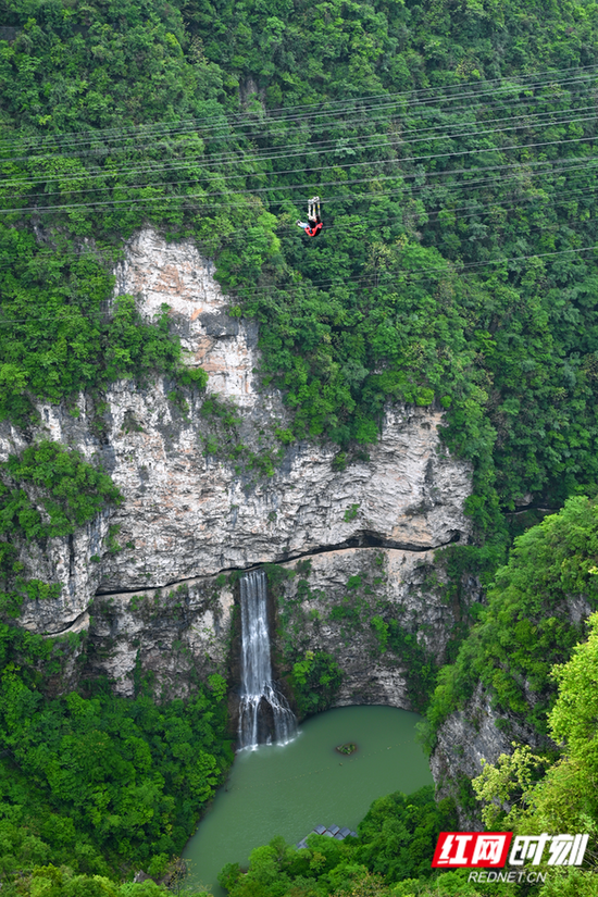 峡谷之上，游客在体验高空滑索。