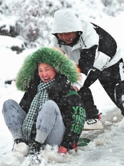 在湘西土家族苗族自治州花垣县，人们在雪中玩耍。新华社 图