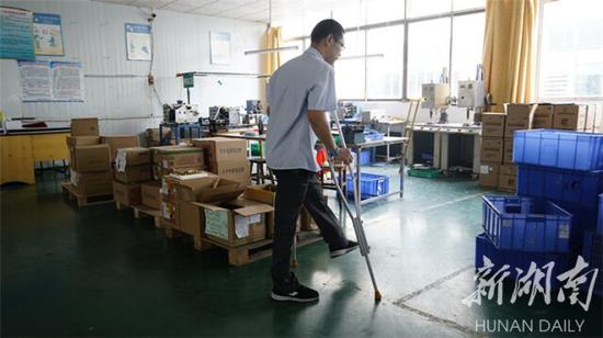 ▲肖卫兵每天都要拄着拐杖上班下班。