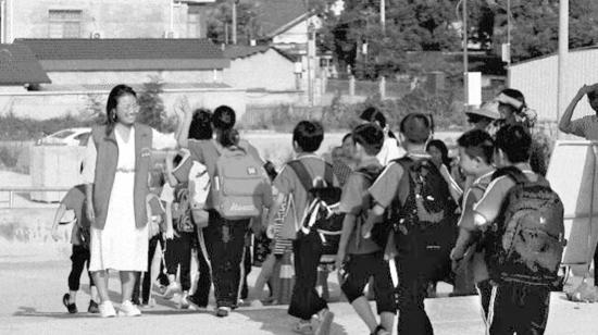 常德石门县壶瓶山镇南坪完小校长张晓春与学生击掌。 图/记者李琼皓
