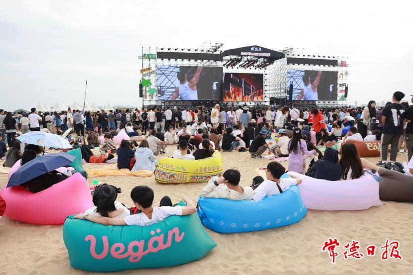 10月2日，游客躺在沙滩上享受惬意的音乐时光 常德日报记者 刘颂 肖芳影 摄