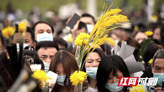 民众手捧菊花、稻穗来到殡仪馆送别袁隆平院士。