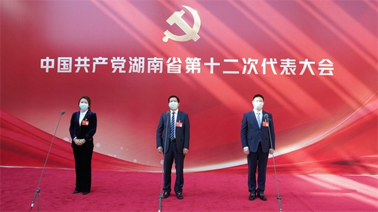 省党代表站在话筒前，接受记者采访。