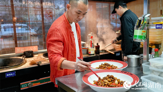 肖亮现炒荷塘土鸡。人民网记者 吴茜薇摄