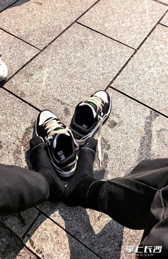 贾先生将小女孩救上岸后来到公园外晒鞋袜