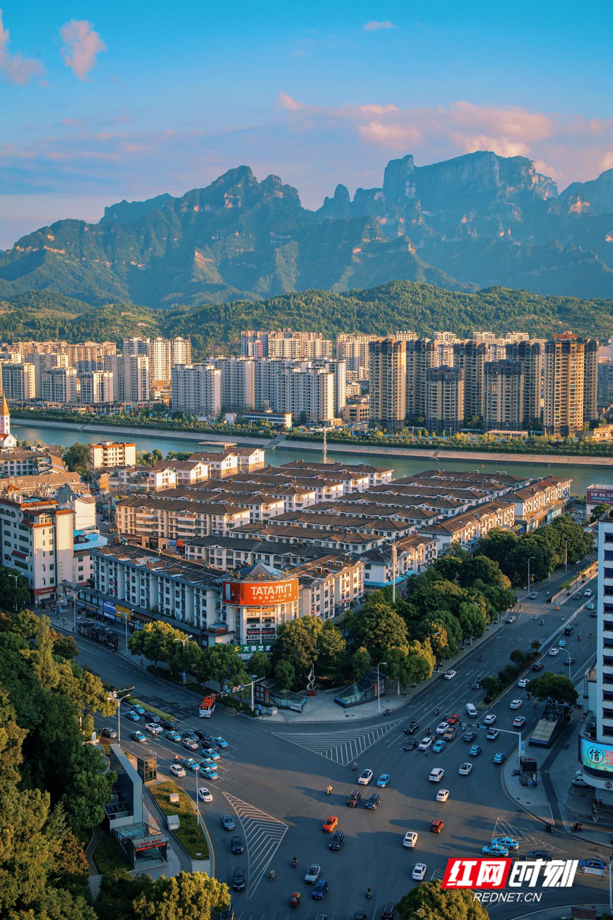 在迎宾路口向天门山望去，一栋栋楼房在天门山下排列得井然有序。