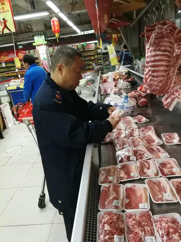 △执法人员在生鲜肉区检查猪肉