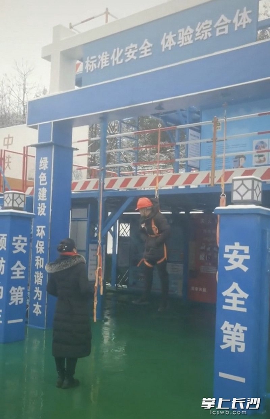 视频中,妻子对吊在半空的丈夫讲安全的重要性。视频截图