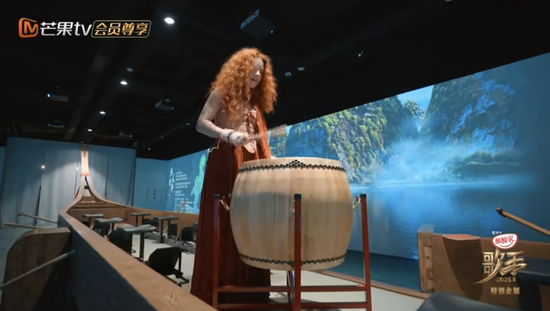在五溪非遗园,歌手艾莉西亚·伊芙琳体验燕尾龙舟的鼓乐