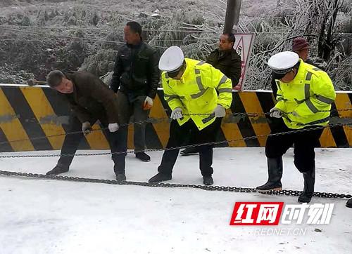 金石桥镇交警中队干警正在省道312云雾山村冰雪道路上为冲到路边的货车开展救援。