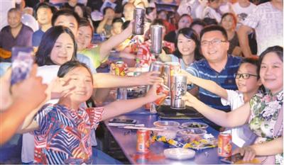 8月16日,消费者在重庆市渝北艺术欢享夜市集现场举杯欢聚。新华社记者 王全超摄