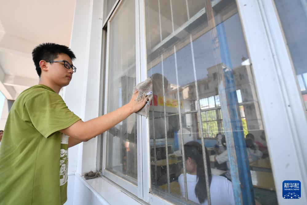 9月1日，在湖南华容团洲学校，学生在清洁教室窗户。新华社记者 陈泽国 摄