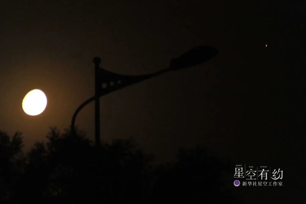 这是2014年5月11日晚在山西省运城市新绛县拍摄的火星合月。（新华社发）