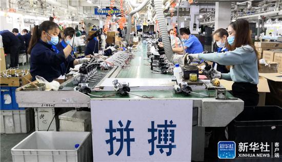 ↑工人在艾美特电器(深圳)有限公司的电风扇生产线上忙碌(3月2日手机拍摄)。新华社记者 周科 摄