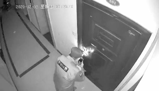 12 月 3 日，长沙裕华名苑小区，保安正在用胶水灌进肖女士家的门锁。视频截图