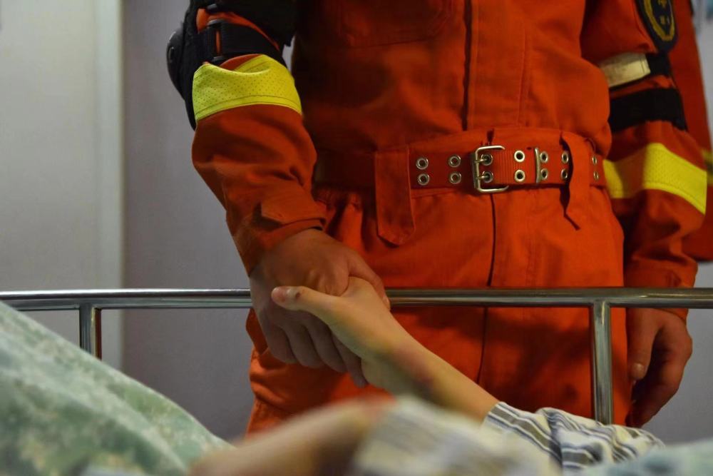 5月2日，张小欢在病房探望小张，小张握住张小欢的手致谢。