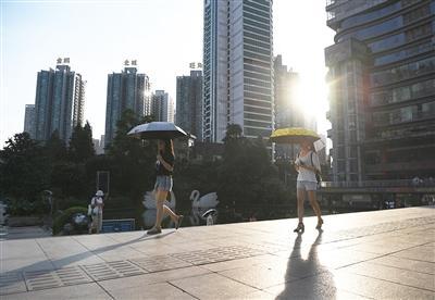 　市民走过重庆市江北区观音桥步行街（7月19日摄）。当日，重庆市气象台发布高温红色预警信号，多个区县的气温达40℃以上。 新华社记者 王全超 摄