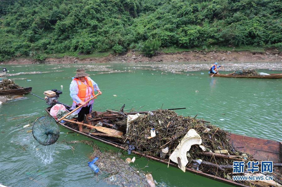 9月6日，在湖南省张家界市永定区茅岩河上，当地村民在清理漂浮物。新华社发（吴勇兵 摄）