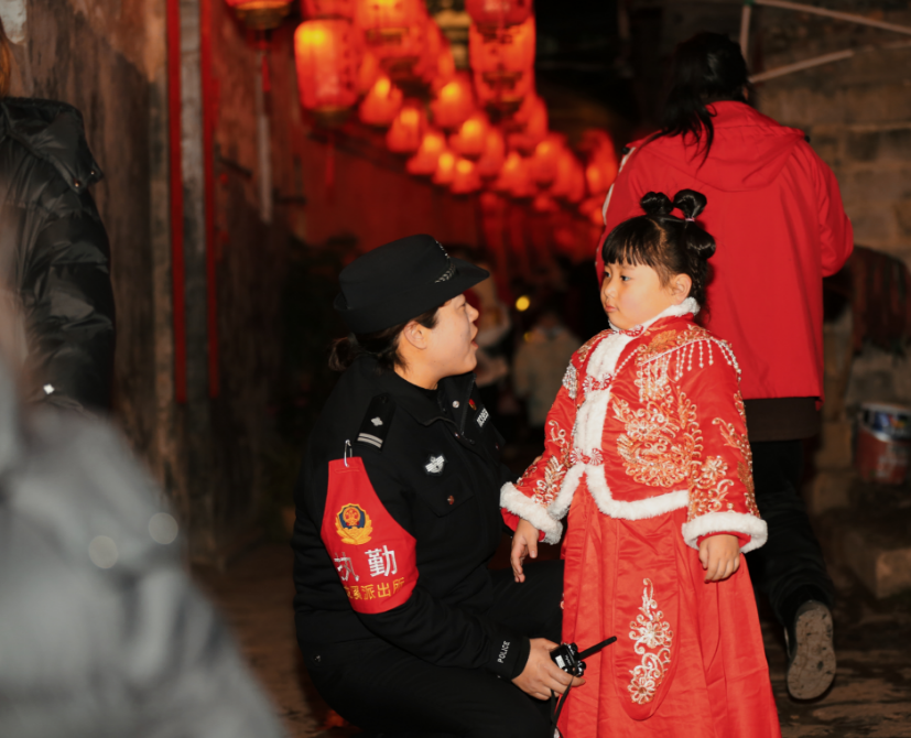 2月4日晚,怀化市新晃公安民警在龙溪古镇为迷路女孩找妈妈。