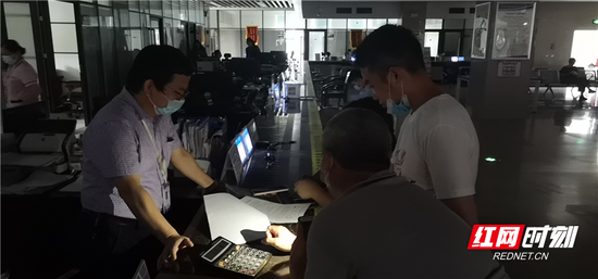 停电不停业务,窗口工作人员用手机照明继续为群众办事。