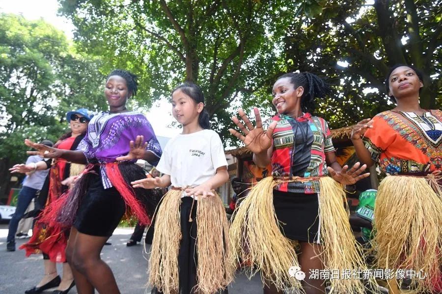 6月15日，河村非洲文化园，Daphine（达芬）（右四）、Darlin（达琳）（右二）、Jeninah（珍妮娜）（右一）在教游客跳非洲民族舞蹈。